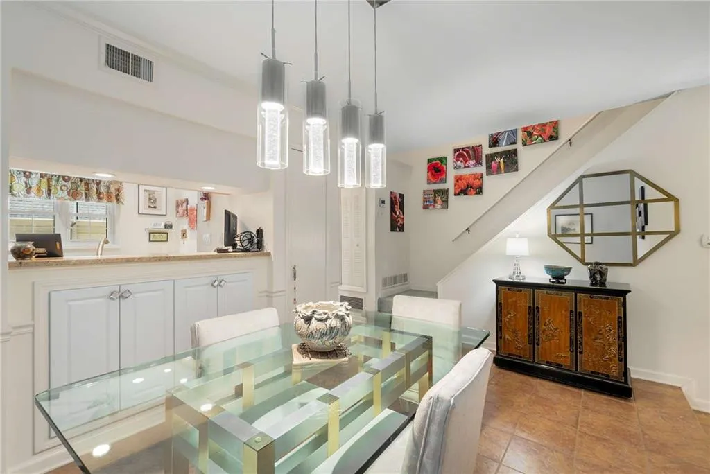 Dining space with light tile patterned floors, visible vents, and baseboards