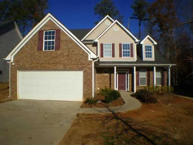 Brick and siding exterior with gabled rooflines, an attached garage, and a covered front porch with white columns