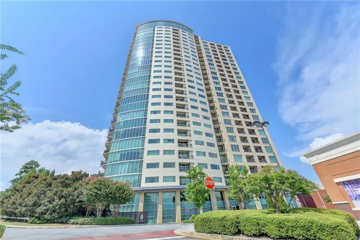 Modern high-rise residential building featuring a curved glass facade and multiple balconies