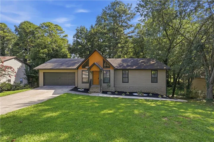 Siding exterior with a covered entry, attached garage, and a concrete driveway