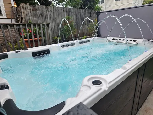 View of swimming pool with a hot tub
