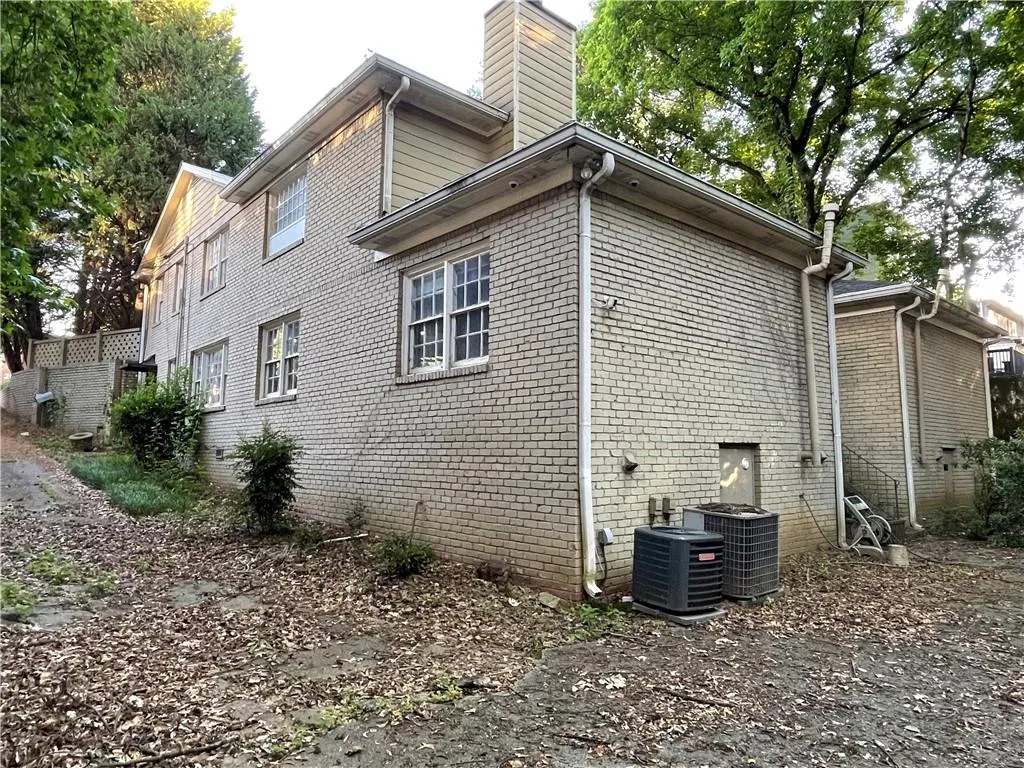 View of home's exterior with a chimney and brick siding