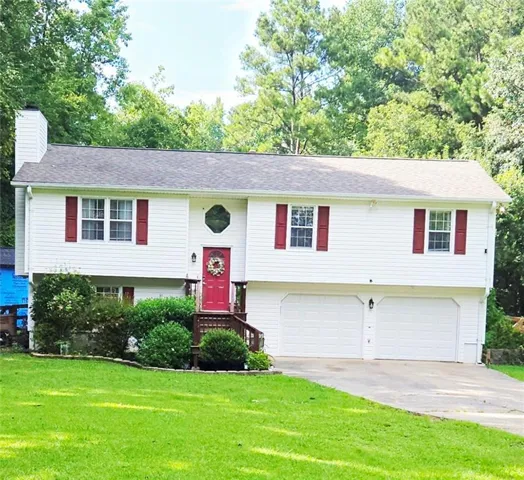 White siding exterior with red shutters, two-car garage, and a red front door