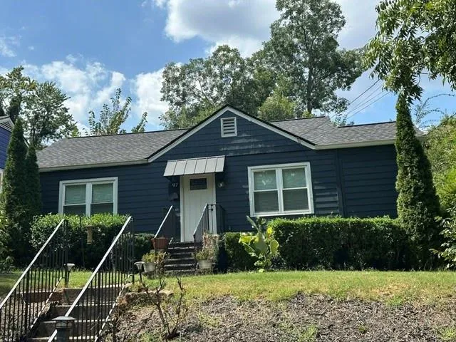 Siding exterior with a gable roof and an awning over the entry
