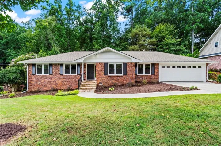 Red brick exterior with white trim, a single-car garage, and a concrete walkway