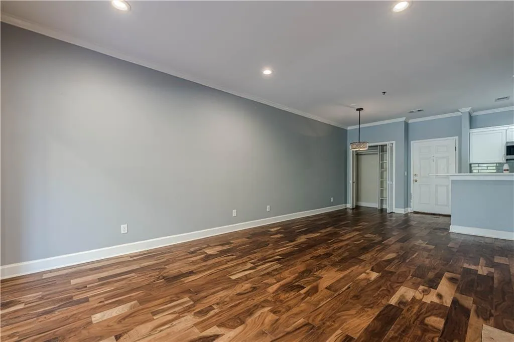 Unfurnished living room with recessed lighting, ornamental molding, baseboards, dark wood-style floors, and visible vents