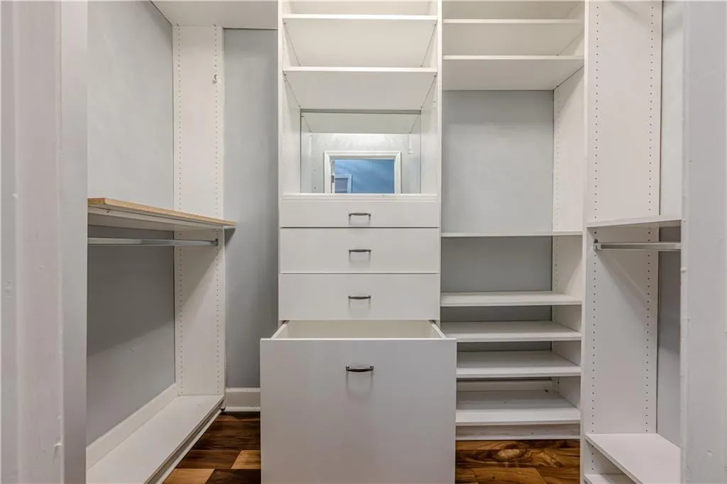 Walk in closet featuring dark wood finished floors