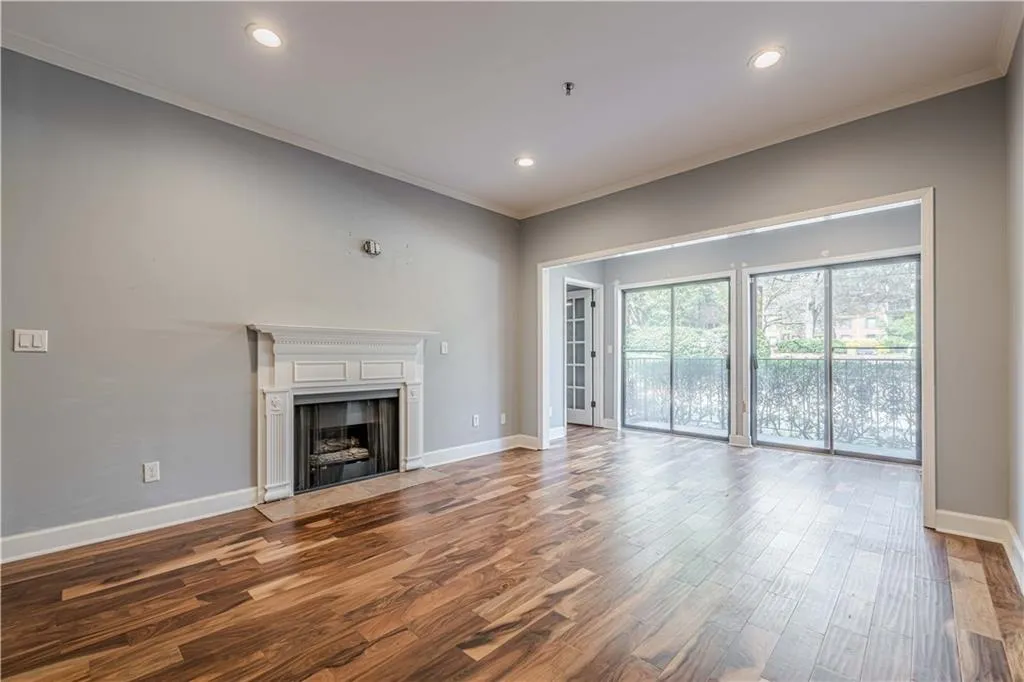 Unfurnished living room featuring recessed lighting, ornamental molding, baseboards, and wood finished floors
