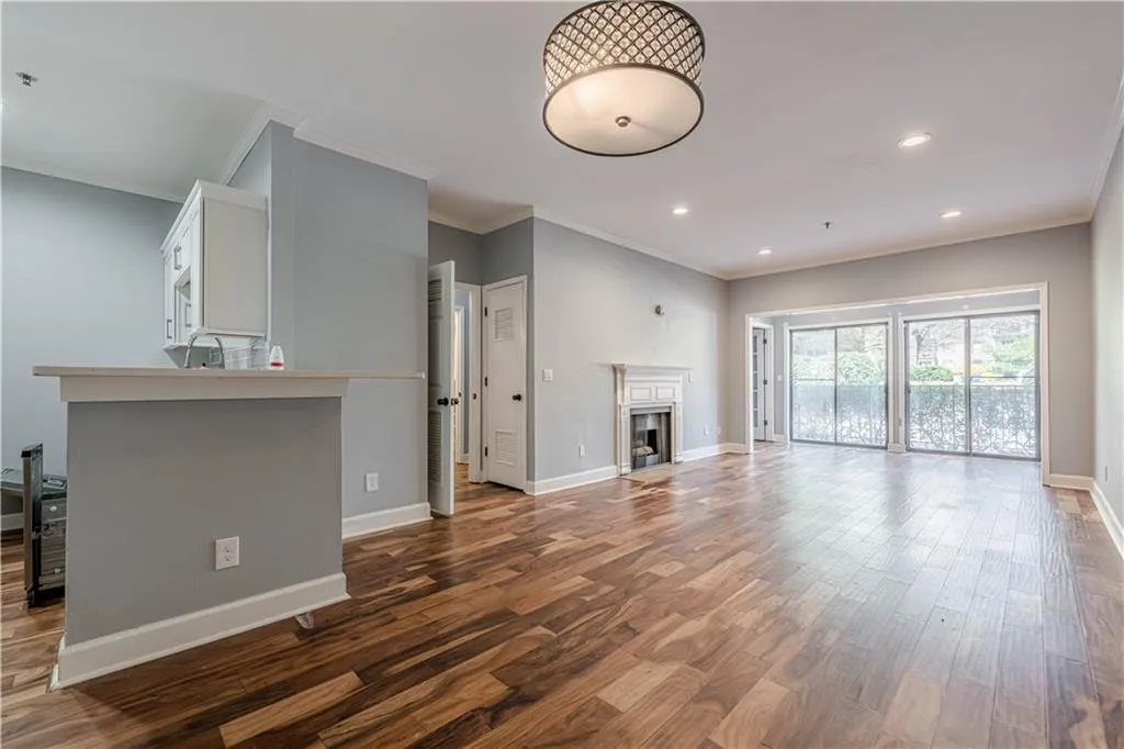Unfurnished living room featuring dark wood-type flooring, baseboards, a fireplace, and crown molding