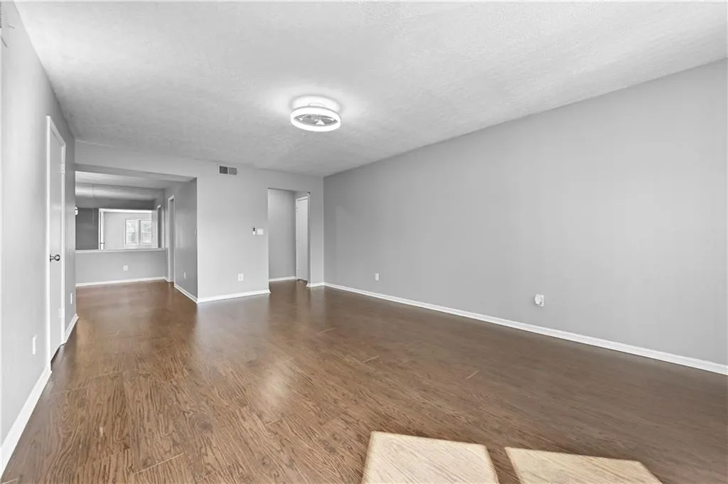 Spare room featuring dark hardwood / wood-style floors and a textured ceiling
