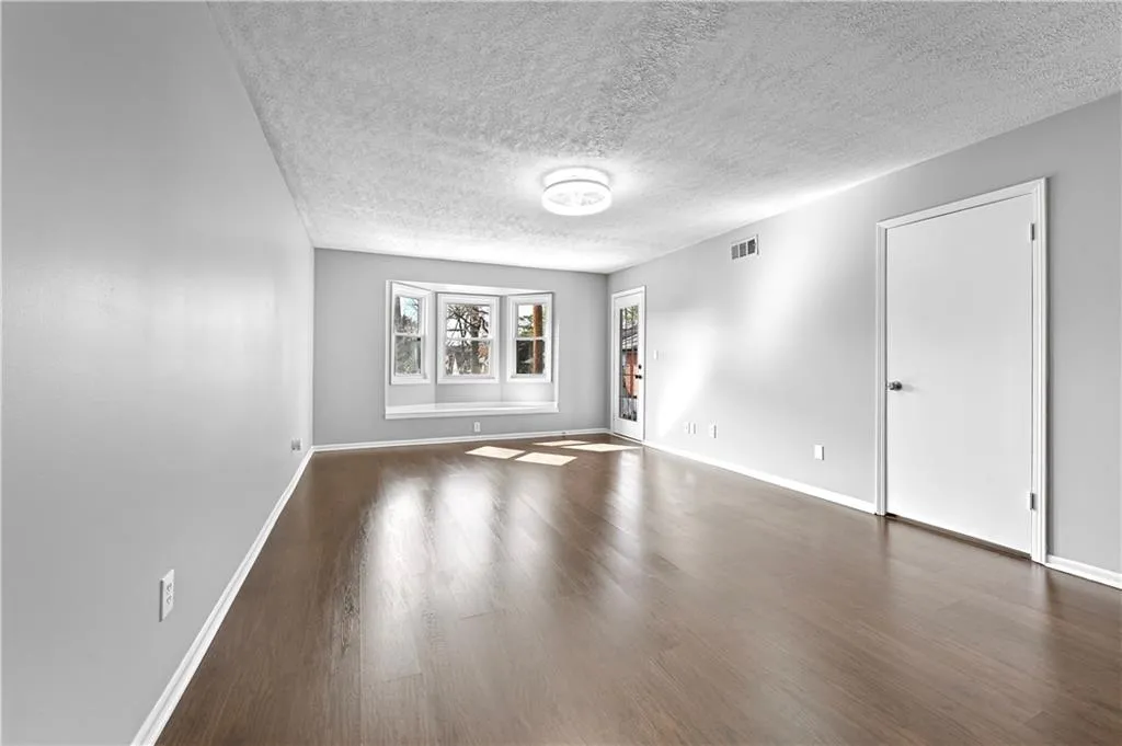 Unfurnished room with dark hardwood / wood-style floors and a textured ceiling