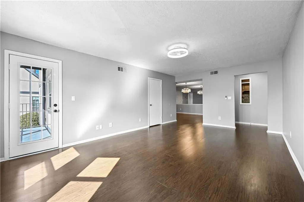 Unfurnished living room with a textured ceiling and dark hardwood / wood-style flooring