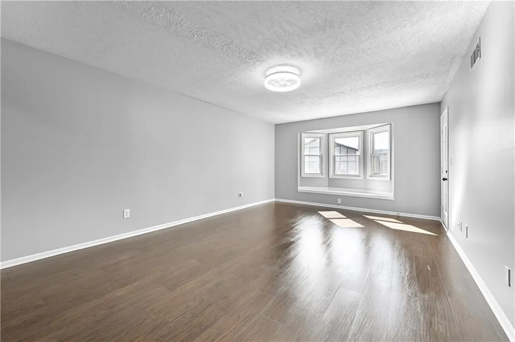 Spare room with dark hardwood / wood-style flooring and a textured ceiling