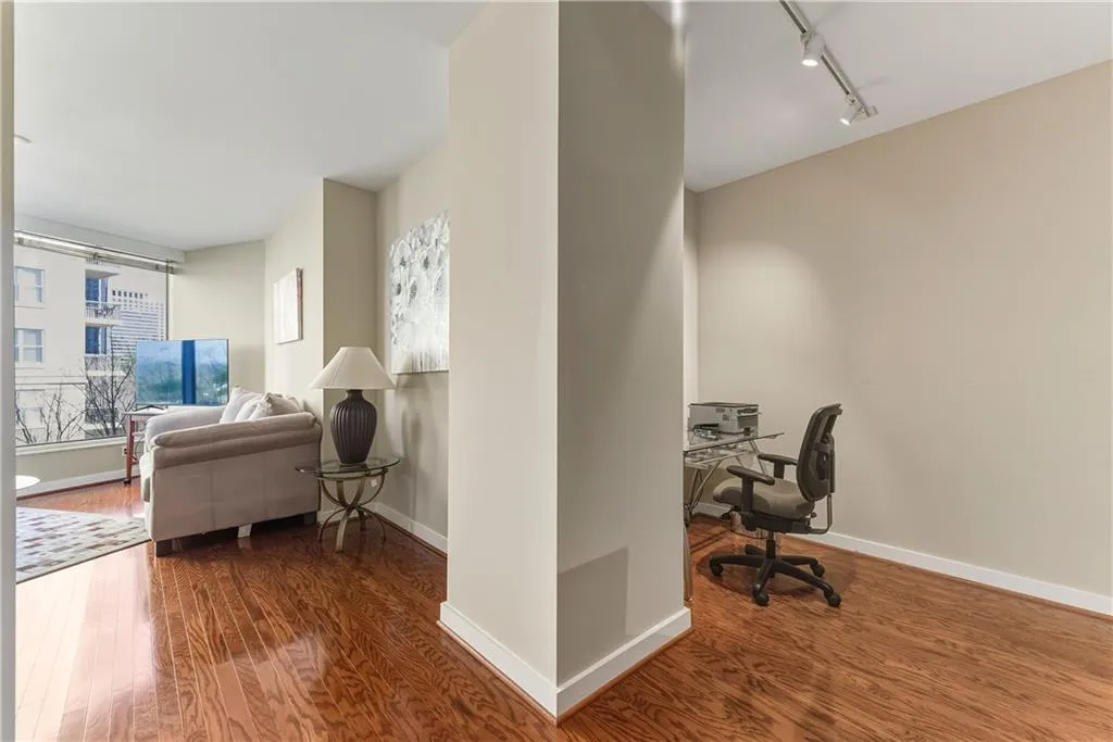 Wood-finish flooring throughout, featuring a large window, recessed lighting, and track lighting