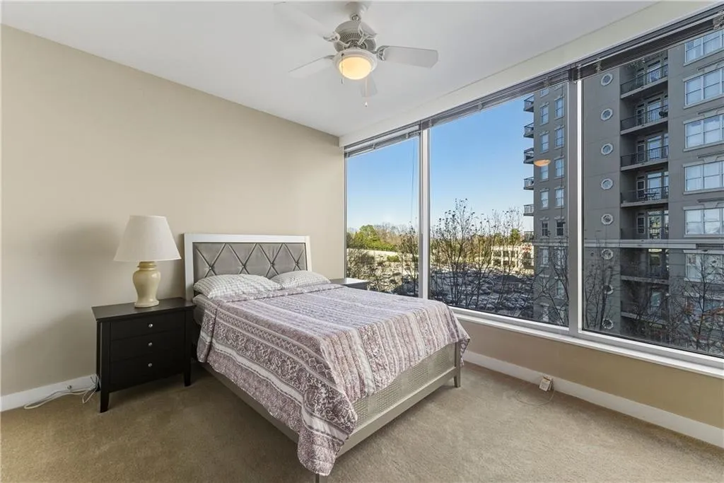 Expansive floor-to-ceiling windows, sloped ceiling, recessed lighting, and a ceiling fan with integrated lighting