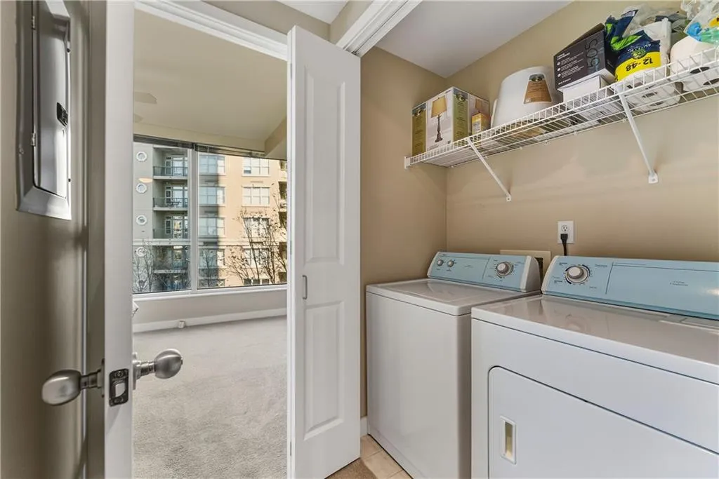 Dedicated laundry area featuring a washer and dryer, wire shelving, and neutral wall paint