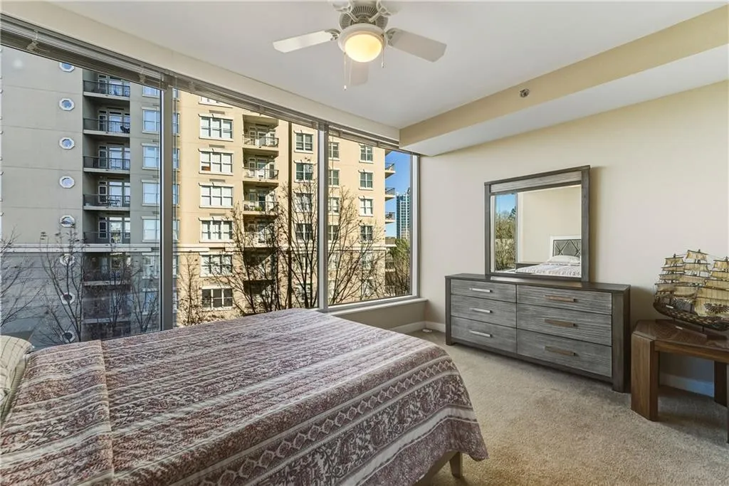 Floor-to-ceiling windows, ceiling fan with integrated lighting, wall-to-wall carpeting