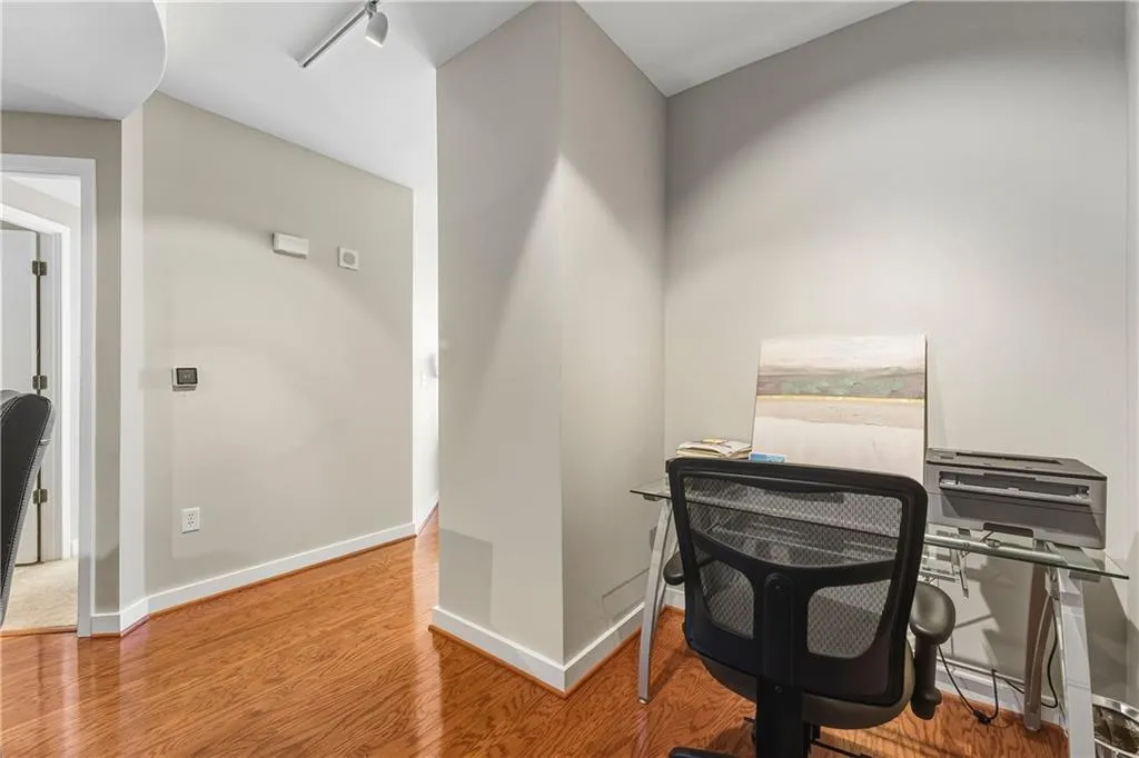 Hardwood flooring throughout, leading to a dedicated workspace with track lighting and neutral wall tones