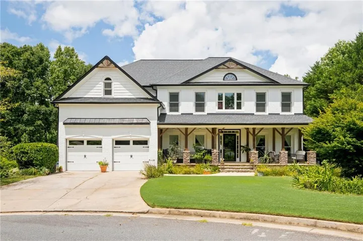 White painted brick exterior with dark trim and a dark shingle roof