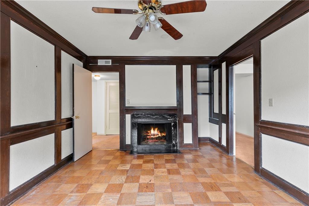 Unfurnished living room featuring ornamental molding, light colored carpet, ceiling fan, and a premium fireplace