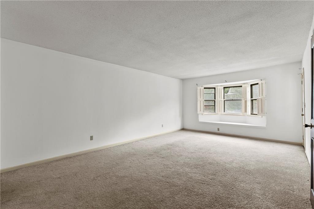 Carpeted empty room with a textured ceiling