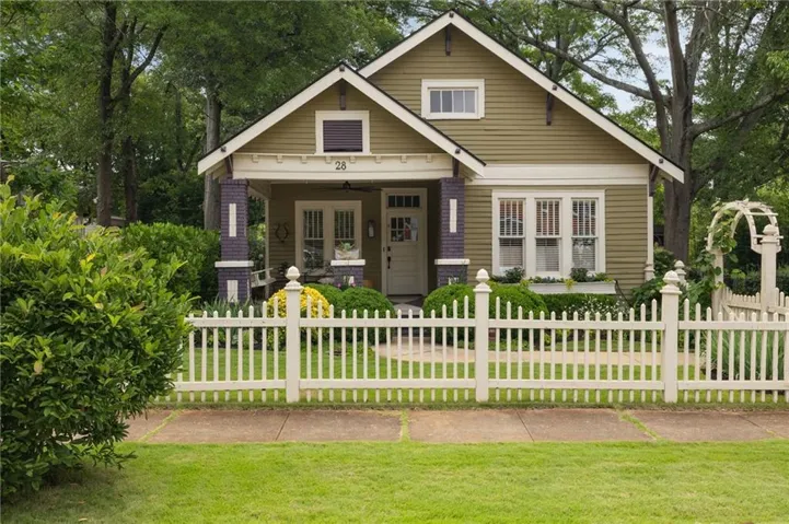 Craftsman-style home with a fenced front yard and a porch