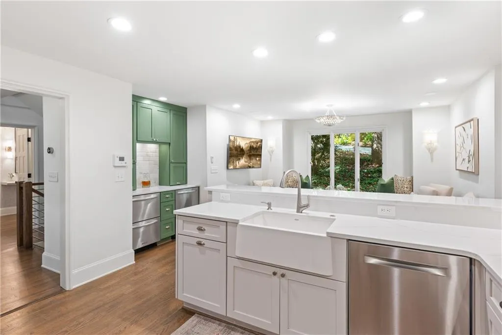 Renovated white kitchen with upgraded appliances and solid surface countertops