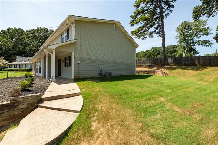 Two-story structure with light green siding, covered front entry, and a concrete walkway