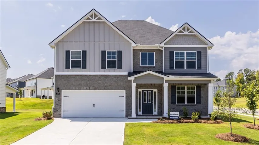 Traditional-style exterior with a gray brick facade, board and batten siding, dark shutters, and a two-car garage