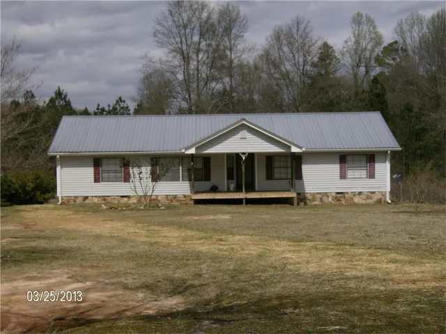 Ranch-style home featuring a porch and a front lawn