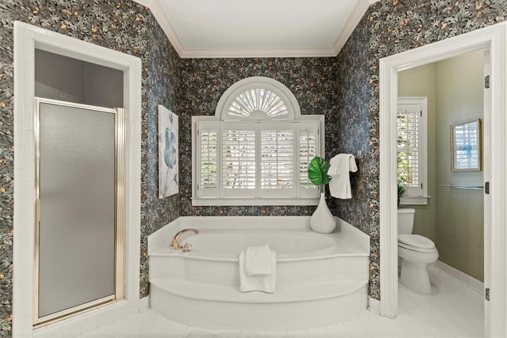Step into the spacious primary bathroom, featuring an oversized tub and separate stand-up shower. Step into the spacious primary bathroom, featuring an oversized tub and separate stand-up shower.
