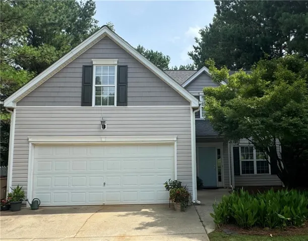Two-story residence featuring light gray horizontal siding and gray shake siding on the upper gable