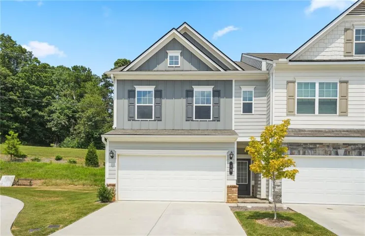 Craftsman inspired home featuring board and batten siding, a garage, and driveway