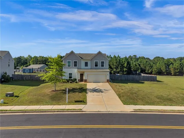 Two-story home with a two-car garage, concrete driveway, and a fenced backyard