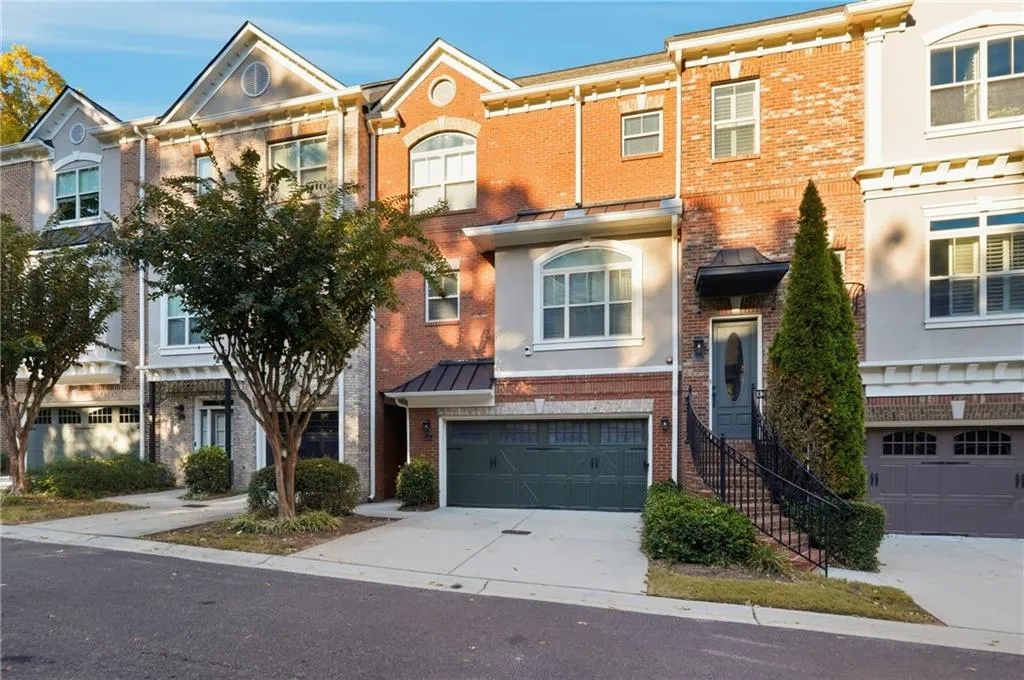 Traditional-style home featuring brick siding, driveway, and an attached garage