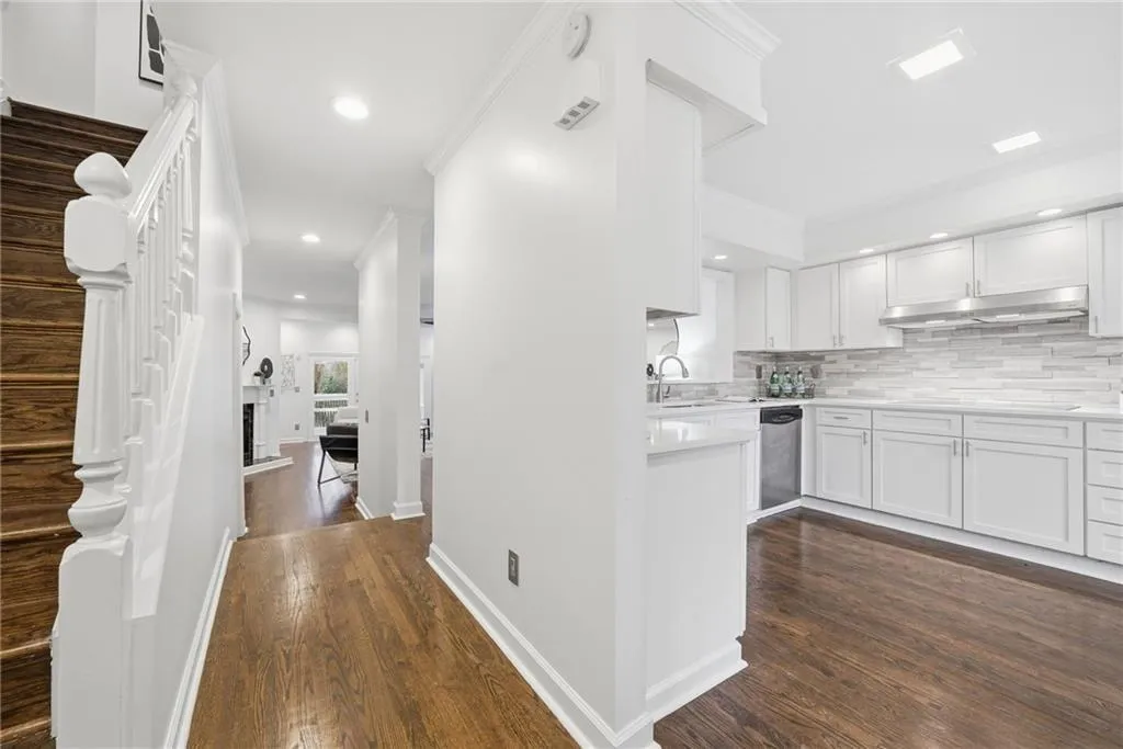 Kitchen featuring white cabinets, dark wood-style flooring, recessed lighting, backsplash, and dishwasher