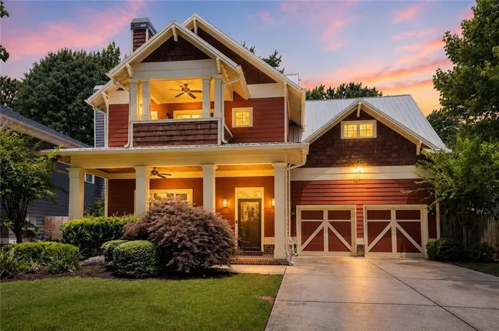 Craftsman-style facade with a covered front porch, shaker-style siding, and a two-car garage with carriage-style doors