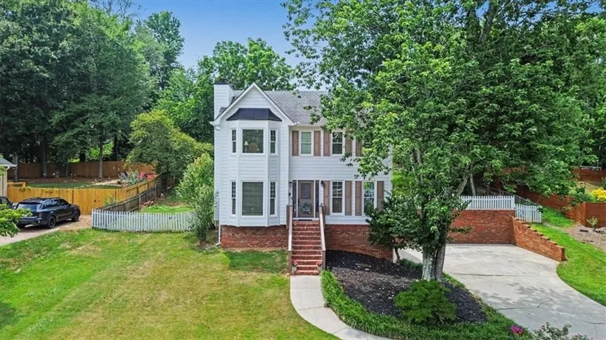 Traditional two-story residence with white siding and brick accents