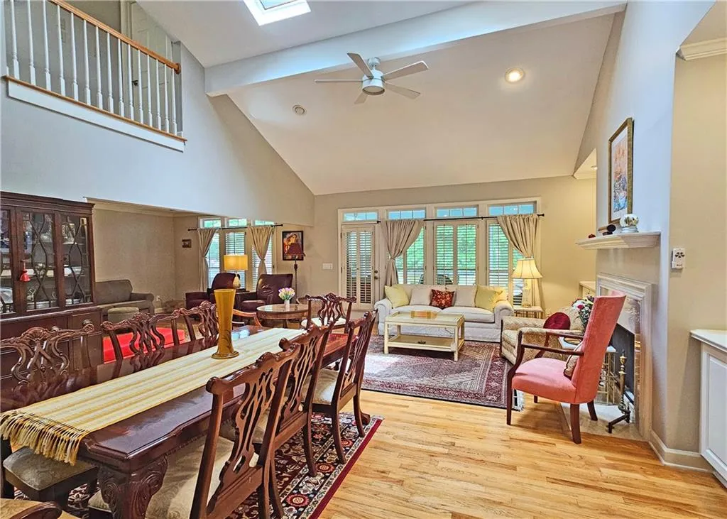 Dining room with a high ceiling, wood finished floors, baseboards, stairs, and recessed lighting