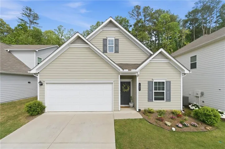 This single-story residence features a light-colored siding exterior with dark grey shutters and a front entry garage