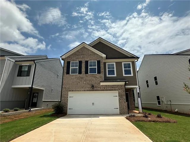 Contemporary two-story residence featuring a brick and siding exterior, an attached two-car garage, a concrete driveway, and a covered entry