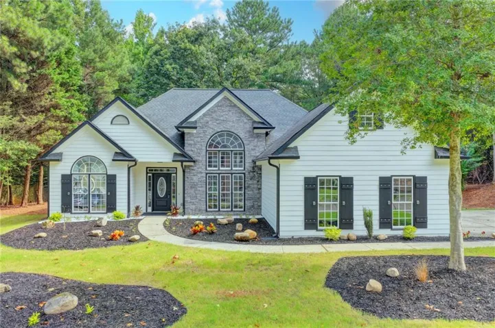 White siding exterior with a prominent stone facade accent