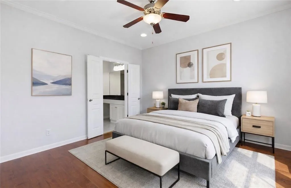 Bedroom with dark wood-style flooring, connected bathroom, ceiling fan, ornamental molding, and recessed lighting