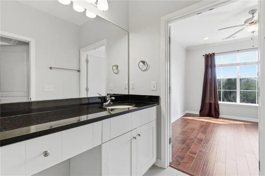Bathroom with ceiling fan, vanity, and light wood-style flooring