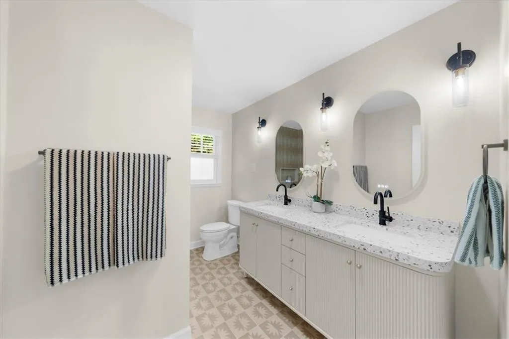 Full bathroom featuring double vanity and toilet