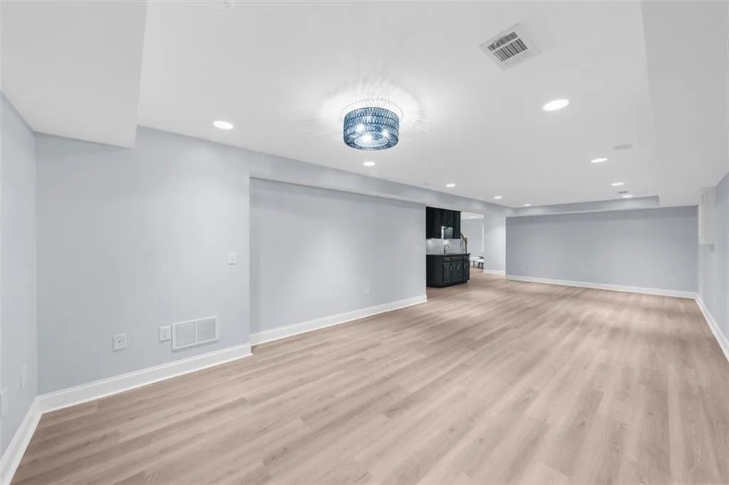 Below grade area with light wood finished floors and recessed lighting