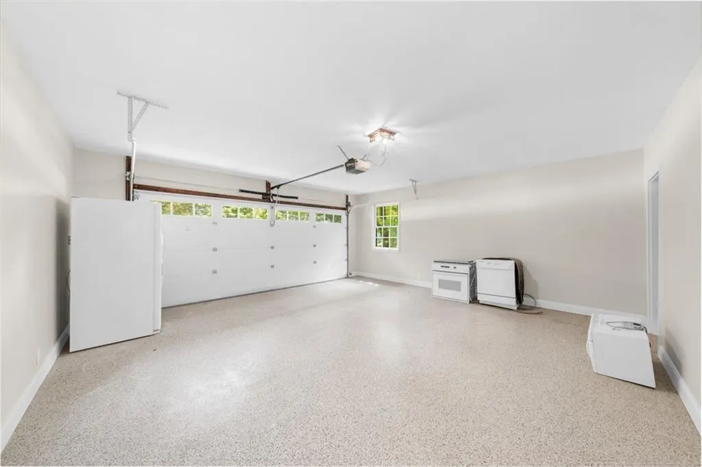 Garage with freestanding refrigerator and baseboards