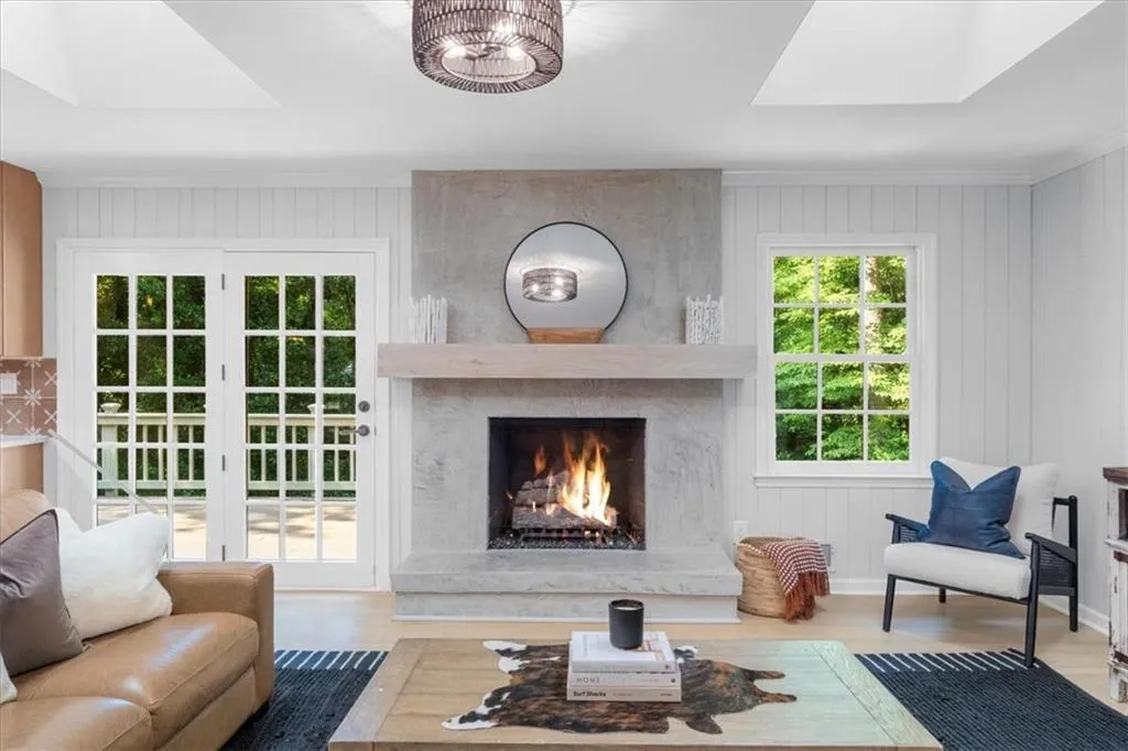 Living area featuring a skylight, wood finished floors, a fireplace, and wood walls