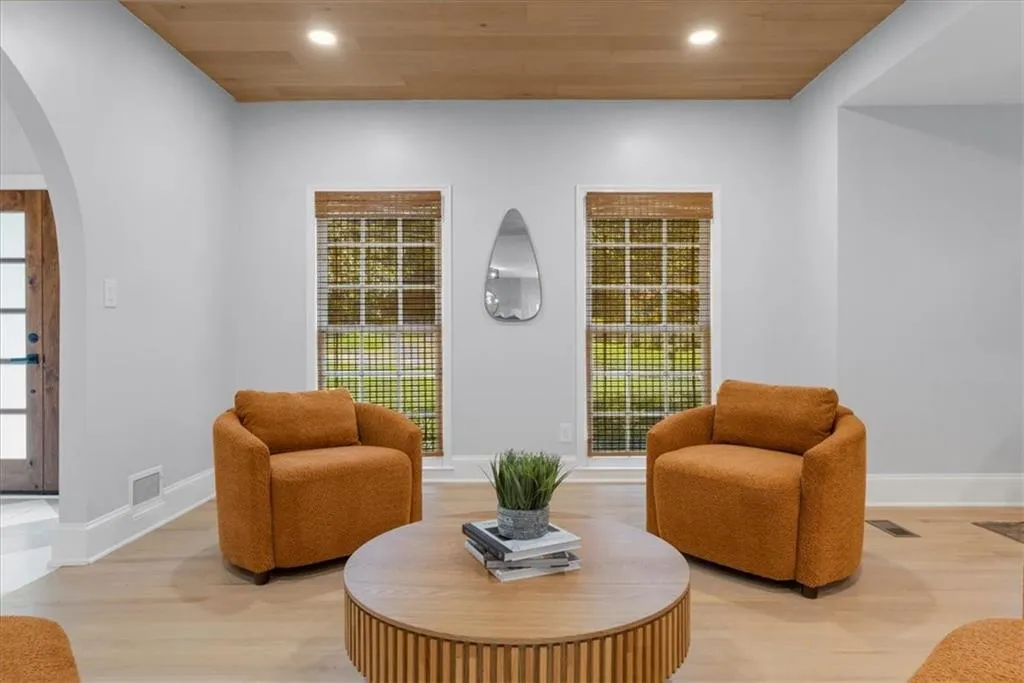 Living area featuring arched walkways, wood finished floors, wooden ceiling, and recessed lighting