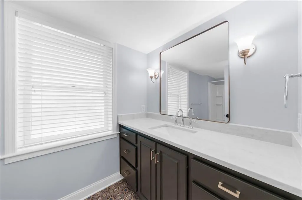 Bathroom featuring vanity, patterned flooring, and plenty of natural light